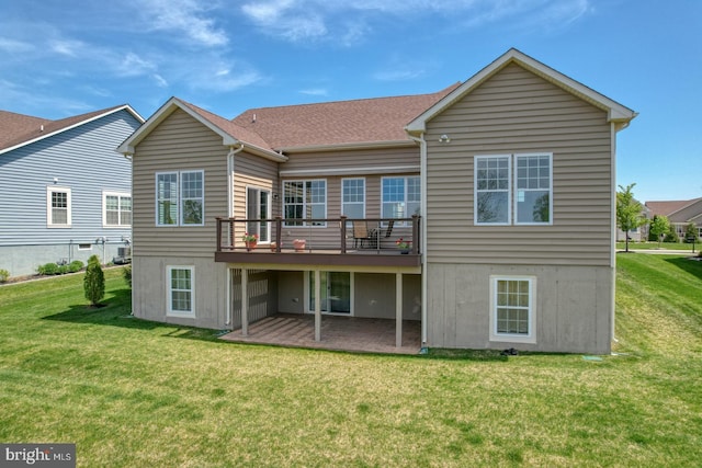 back of house featuring a yard, a wooden deck, and a patio area