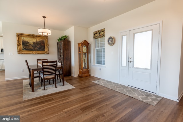 dining space with baseboards and wood finished floors