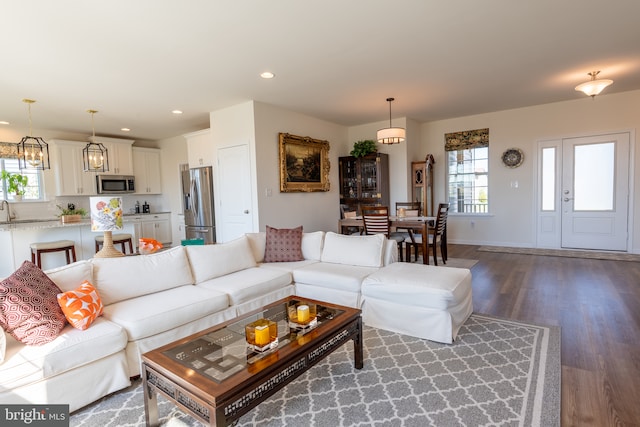 living room with baseboards, plenty of natural light, recessed lighting, and wood finished floors