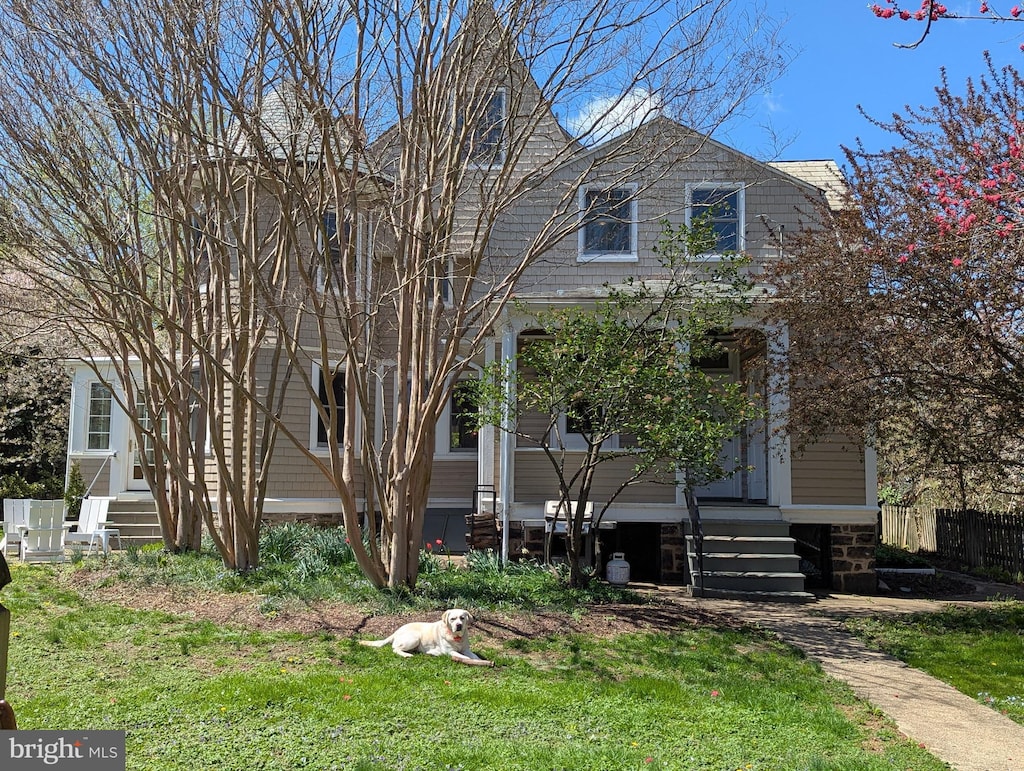 view of front of home featuring a front lawn, fence, and entry steps