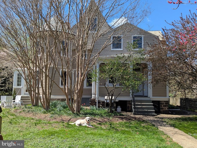 view of front of home featuring a front lawn, fence, and entry steps
