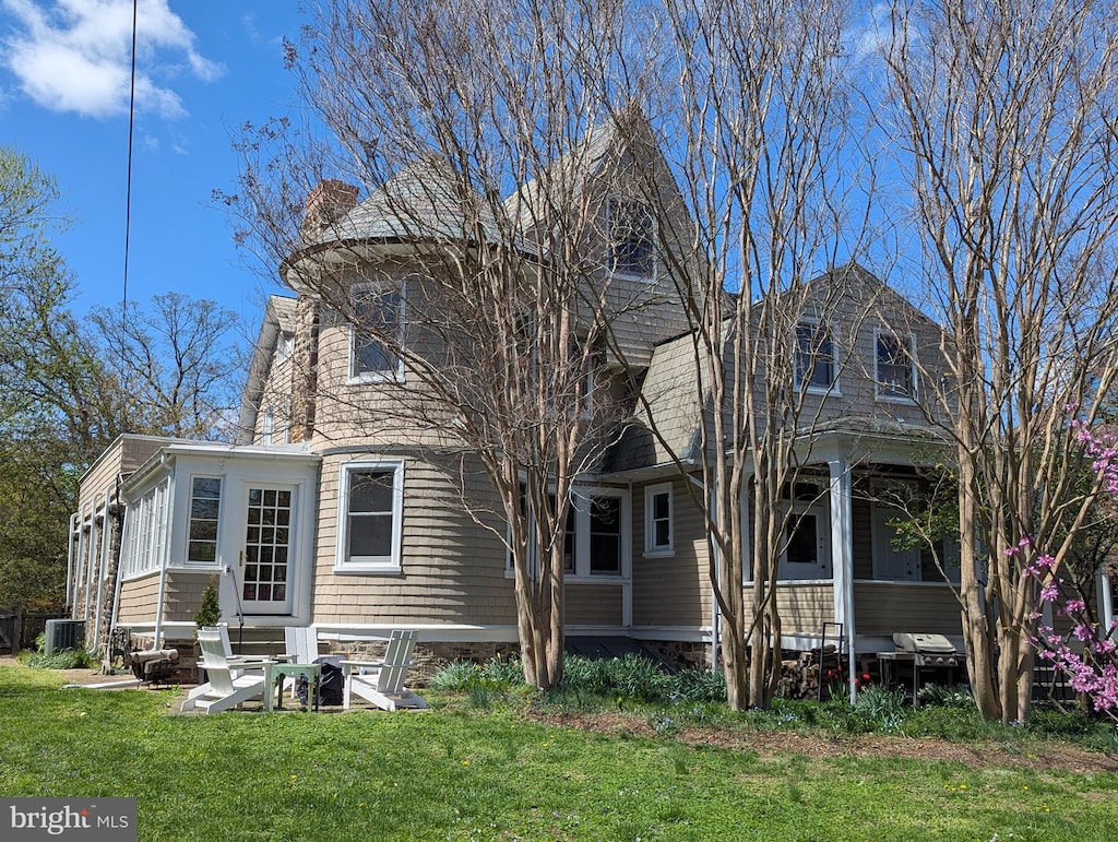 exterior space featuring central air condition unit, a lawn, a chimney, and entry steps