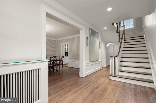 2720 35th Pl NW, Washington, DC 20007 - stairs with ornamental molding, wallpapered walls, wood finished floors, a decorative wall, and a wainscoted wall