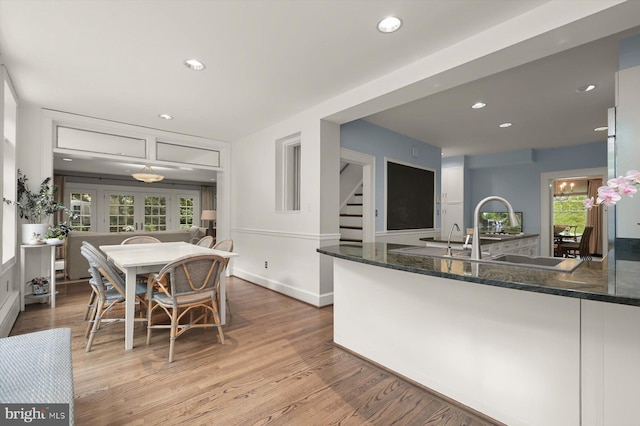 2720 35th Pl NW, Washington, DC 20007 - kitchen with light wood finished floors, dark stone countertops, recessed lighting, a peninsula, and a sink