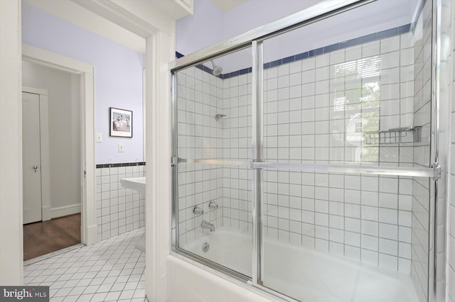 2720 35th Pl NW, Washington, DC 20007 - bathroom featuring combined bath / shower with glass door, tile walls, tile patterned floors, and a wainscoted wall