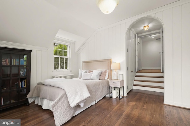 2720 35th Pl NW, Washington, DC 20007 - bedroom featuring wood finished floors, arched walkways, vaulted ceiling, baseboards, and a decorative wall
