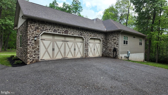 1982 Whyte Ln, Spring Grove, PA 17362 - view of side of property featuring stone siding, a garage, roof with shingles, and asphalt driveway