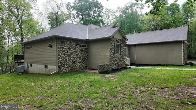 1982 Whyte Ln, Spring Grove, PA 17362 - back of house with stone siding, a yard, central air condition unit, and roof with shingles