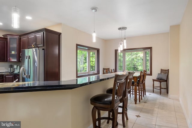 1982 Whyte Ln, Spring Grove, PA 17362 - kitchen with freestanding refrigerator, baseboards, pendant lighting, a breakfast bar area, and glass insert cabinets