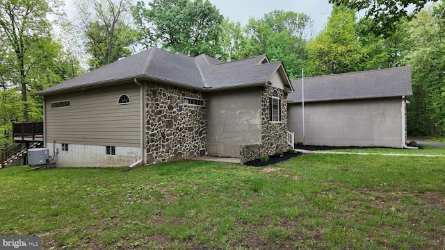 1982 Whyte Ln, Spring Grove, PA 17362 - back of house with stone siding, a yard, central AC, roof with shingles, and a deck