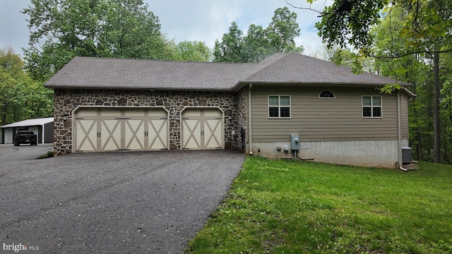 1982 Whyte Ln, Spring Grove, PA 17362 - view of side of property featuring a yard, stone siding, an attached garage, asphalt driveway, and a shingled roof