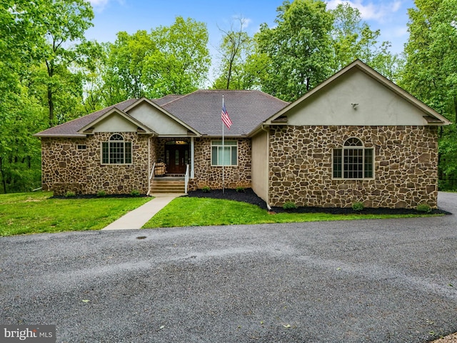 1982 Whyte Ln, Spring Grove, PA 17362 - view of front facade featuring stone siding, a front lawn, a shingled roof, and stucco siding