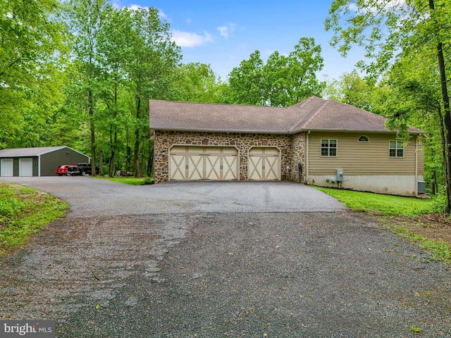 1982 Whyte Ln, Spring Grove, PA 17362 - view of home's exterior featuring asphalt driveway, stone siding, a garage, and a shingled roof