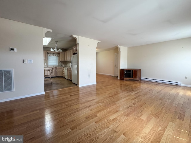 359 Towpath Ln, Pine Grove, PA 17963 - unfurnished living room with a notable chandelier, light wood finished floors, baseboards, a baseboard radiator, and visible vents