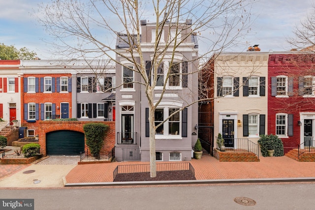 townhome / multi-family property featuring brick siding and driveway