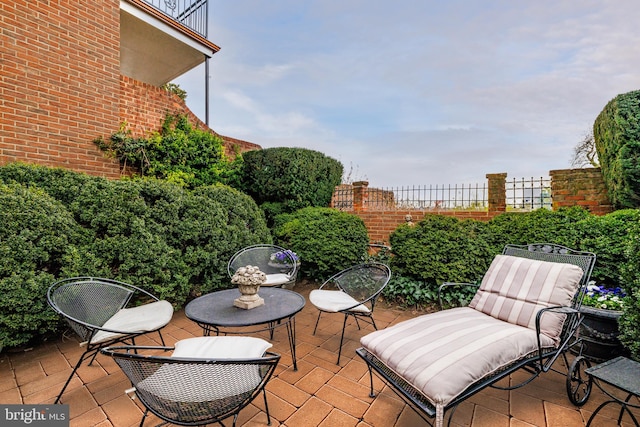 view of patio / terrace with fence and a balcony