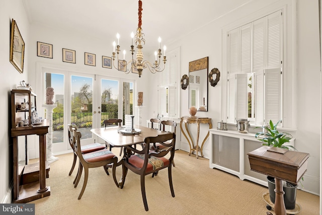 dining area with french doors, a notable chandelier, and light carpet