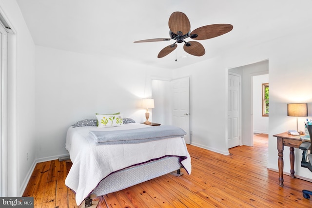 bedroom featuring light wood-type flooring, baseboards, and a ceiling fan