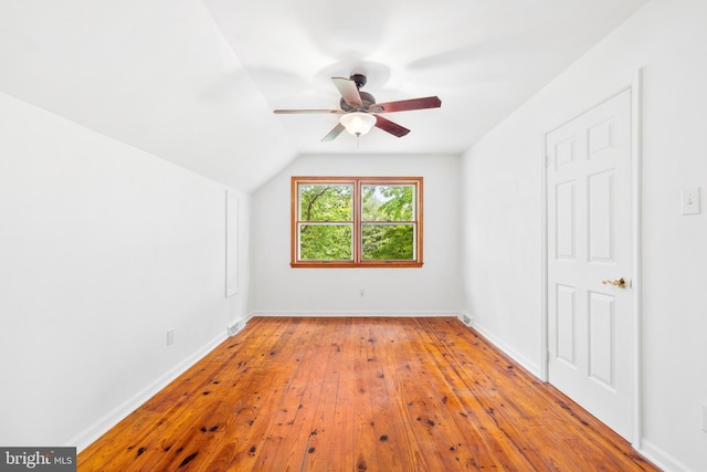 additional living space featuring a ceiling fan, wood-type flooring, vaulted ceiling, and baseboards