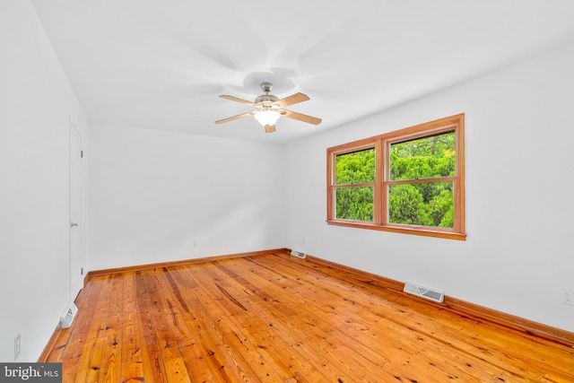 spare room with a ceiling fan, baseboards, and light wood-style flooring