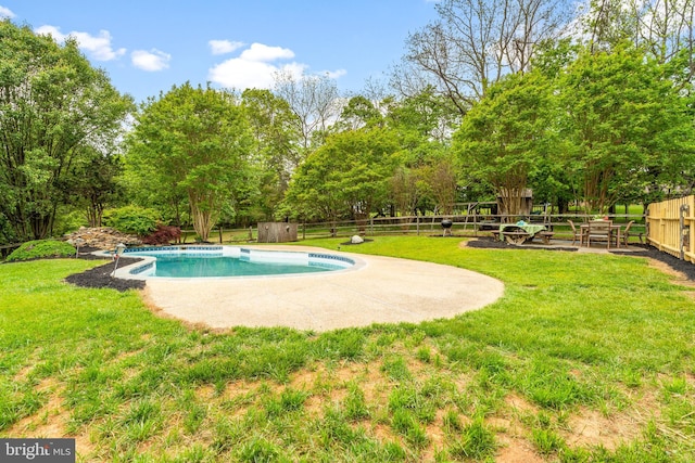 view of pool with view of wooded area and a patio area