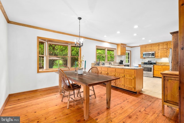 dining area with crown molding, a chandelier, recessed lighting, baseboards, and light wood-type flooring