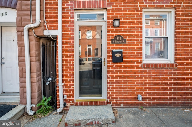 doorway to property with brick siding