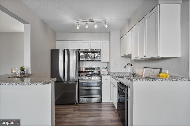 16 S Van Dorn St Unit 406, Alexandria, VA 22304 - kitchen featuring stainless steel appliances, a sink, light stone counters, dark wood-style flooring, and a textured ceiling