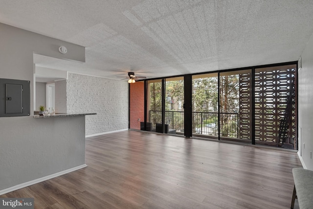 16 S Van Dorn St Unit 406, Alexandria, VA 22304 - unfurnished living room with electric panel, ceiling fan, wood finished floors, baseboards, and a textured ceiling