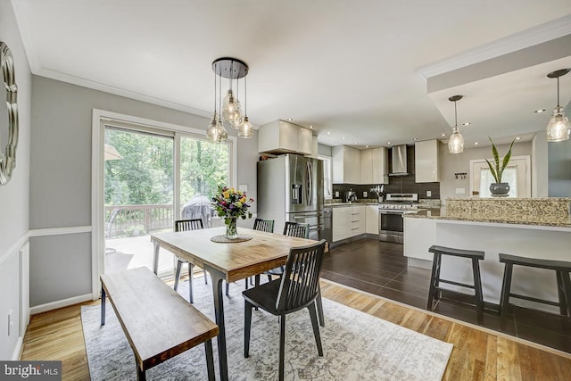 dining space with ornamental molding and dark wood finished floors