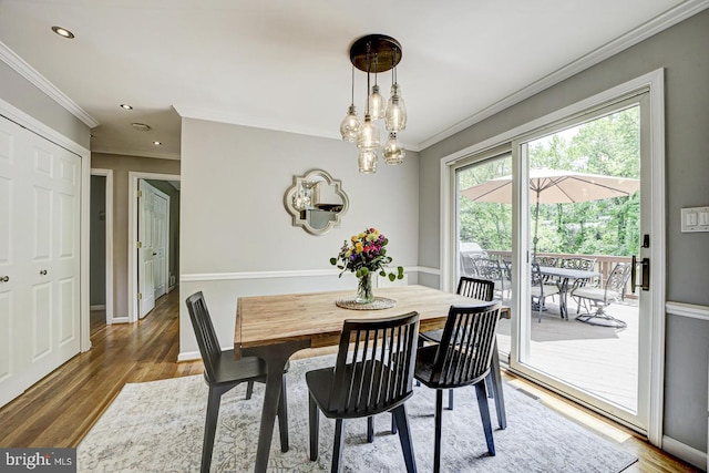 dining space featuring ornamental molding, wood finished floors, a chandelier, recessed lighting, and baseboards
