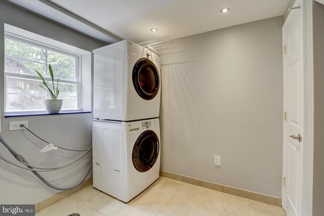 laundry room featuring stacked washer / drying machine, baseboards, recessed lighting, and light tile patterned floors