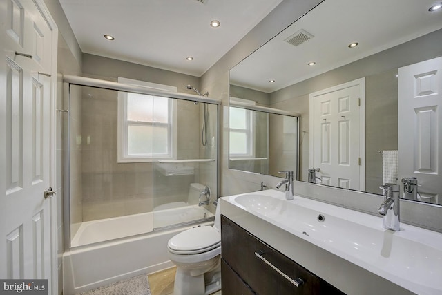 full bathroom featuring vanity, toilet, bath / shower combo with glass door, and recessed lighting