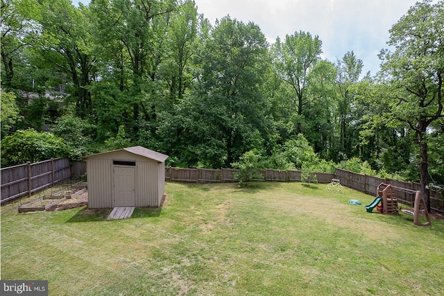 view of yard featuring a storage shed, a playground, and an outbuilding
