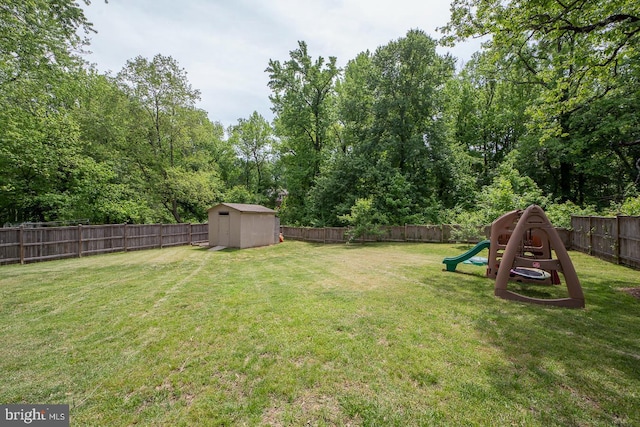 view of yard with a storage shed, an outdoor structure, and a playground