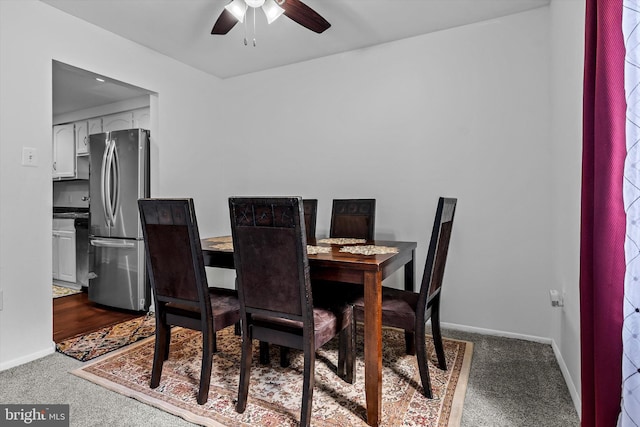 carpeted dining area with baseboards and a ceiling fan