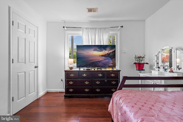 bedroom featuring baseboards, dark wood finished floors, and visible vents