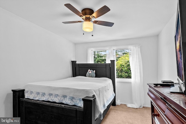 bedroom featuring light colored carpet, a ceiling fan, and baseboards