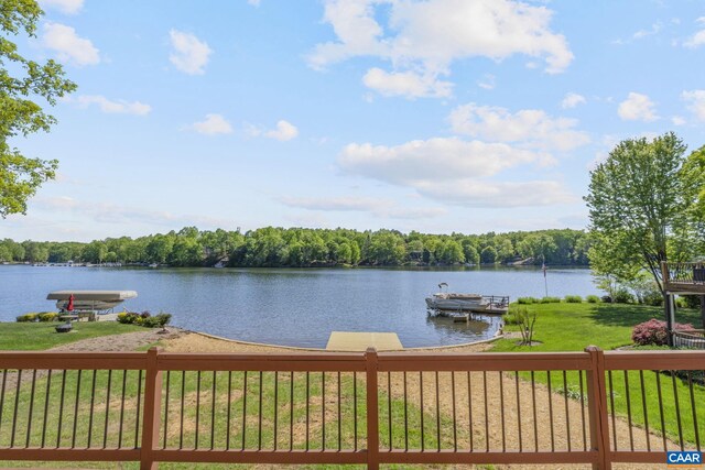view of dock featuring a lawn and a water view