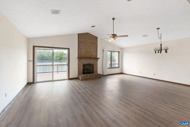 unfurnished living room with ceiling fan with notable chandelier, wood finished floors, and a wealth of natural light