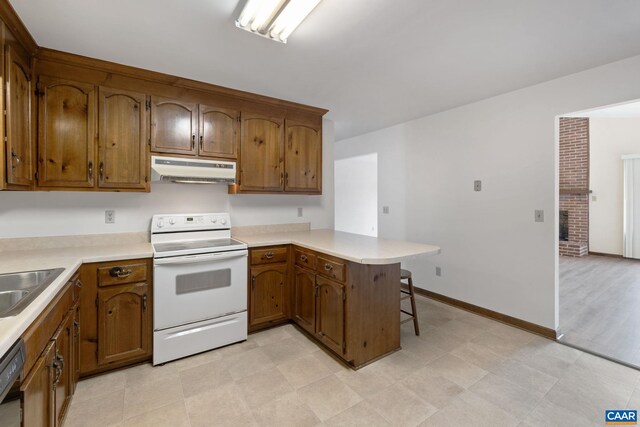 kitchen featuring under cabinet range hood, a peninsula, white electric stove, and light countertops