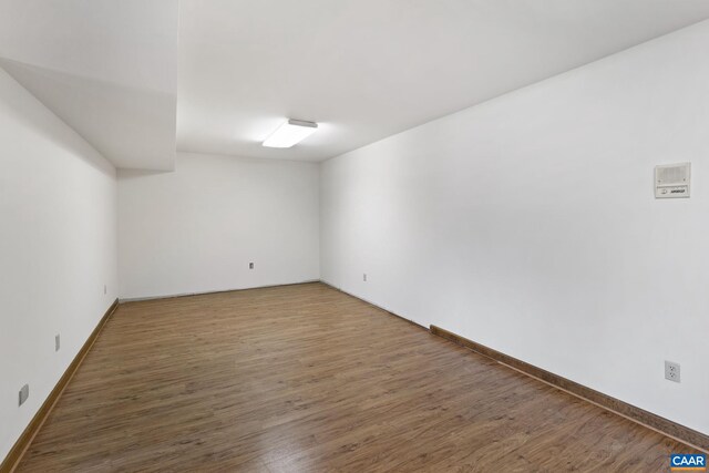 unfurnished room with baseboards and wood finished floors