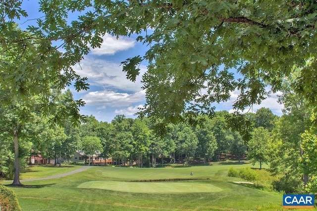 surrounding community with a lawn and view of golf course