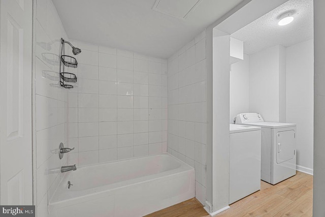 full bathroom with shower / bath combination, wood finished floors, and washing machine and clothes dryer