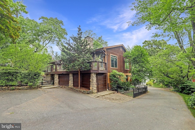 view of home's exterior featuring stone siding and driveway