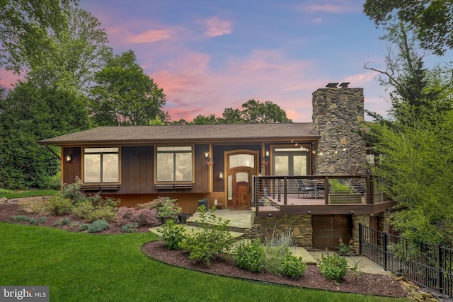 view of front of house with a chimney, a shingled roof, and stone siding