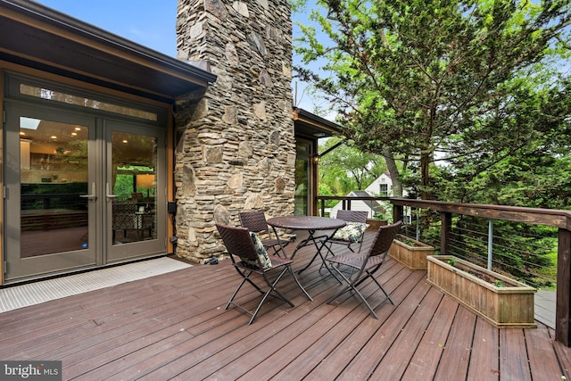 deck with french doors and outdoor dining area