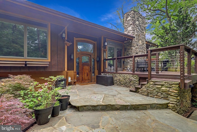 view of exterior entry featuring a chimney
