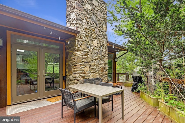 wooden deck with outdoor dining area and french doors