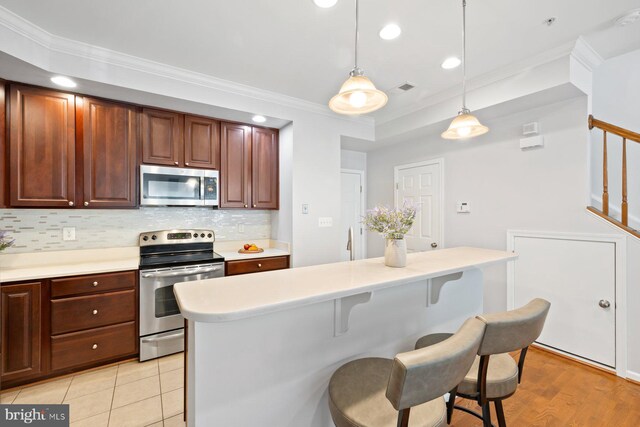 kitchen featuring light countertops, ornamental molding, tasteful backsplash, and stainless steel appliances